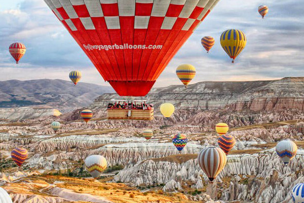 Hot air balloons floating across a fairy chimney hillside