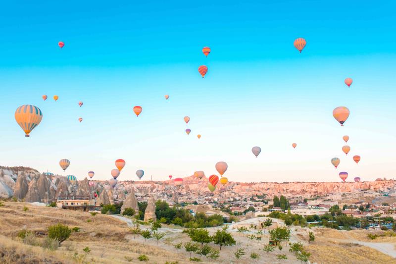 Fairy chimneys in Cappadocia with hot air balloons in background