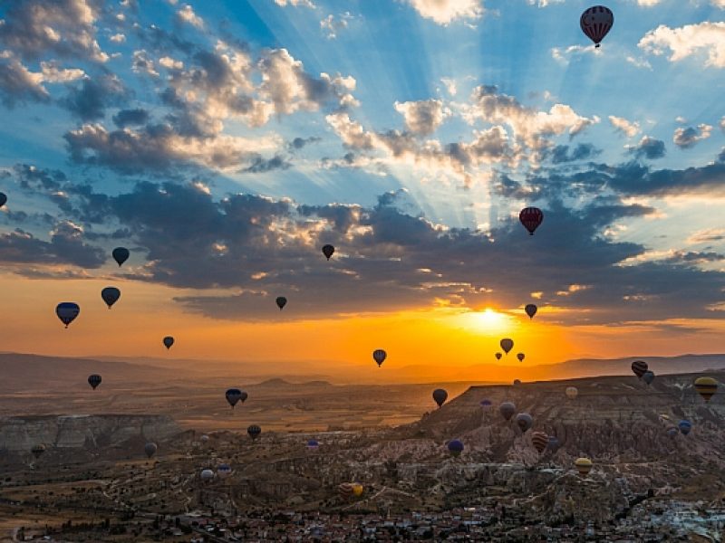 Hot air balloons floating above Cappadocia at sunrise