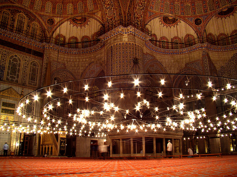 Image of large chandelier, and decorated walls inside a mosque