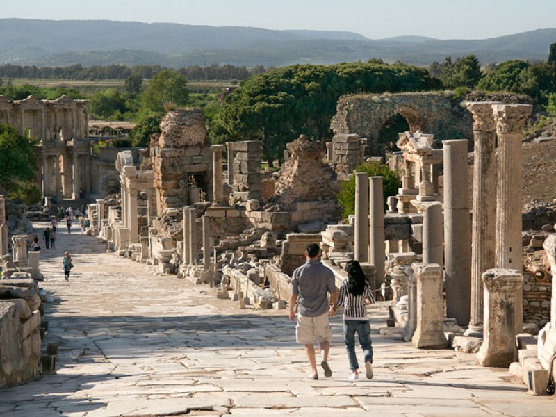Couple walking along marble road at Ephesus