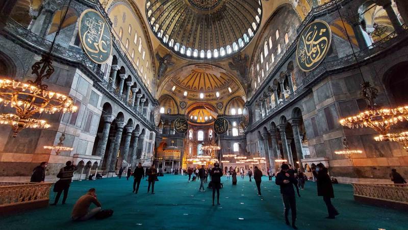 People exploring the grand interiors of Hagia Sophia 