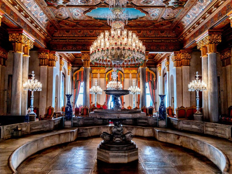 Large chandelier, fountain and painted ceilings in palace room