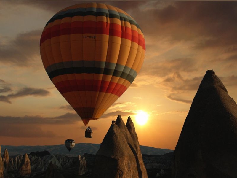 Two hot air balloons flying above fairy chimneys